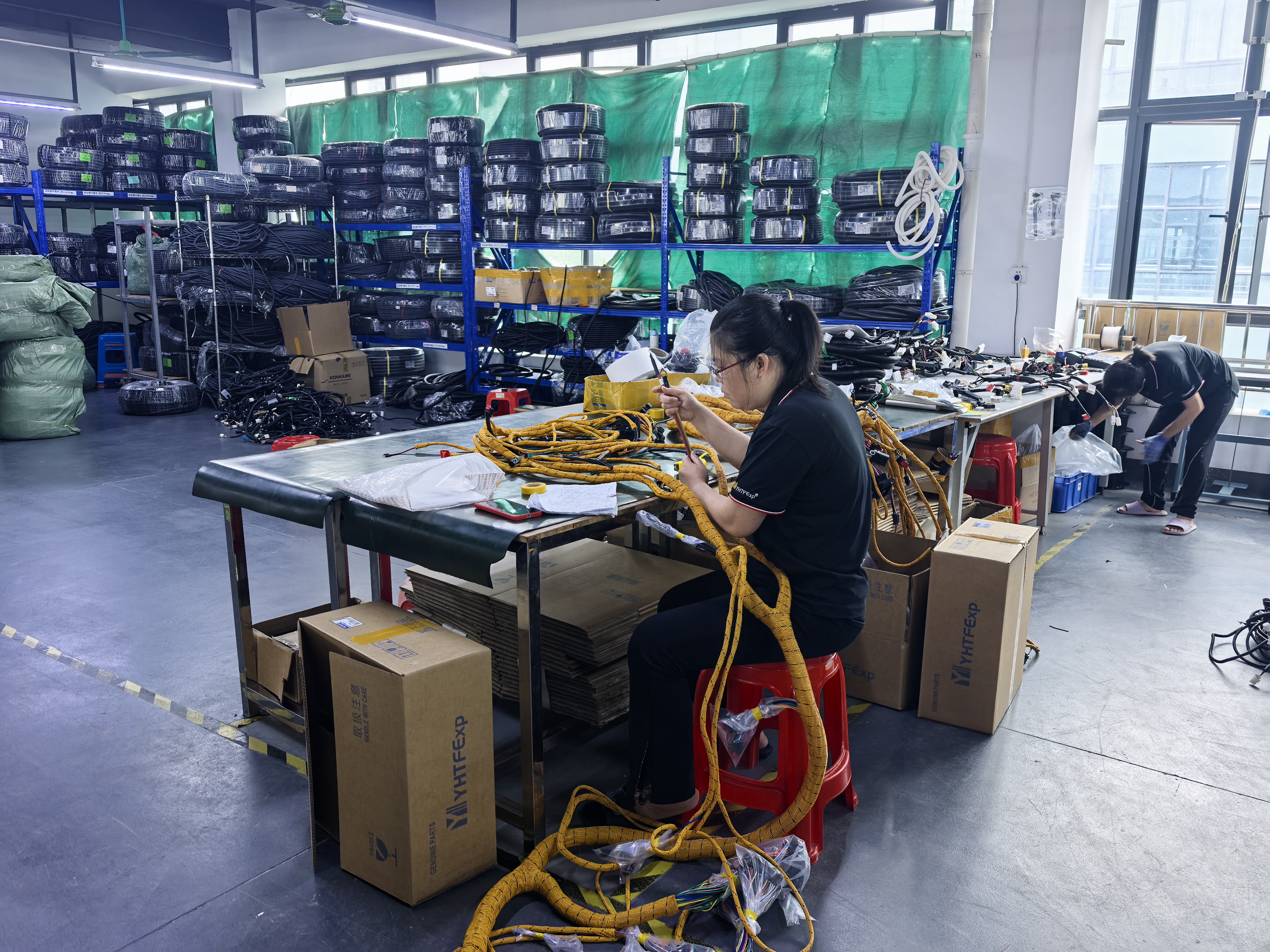Skilled Worker Hand-Assembling Wiring Harness at Workbench